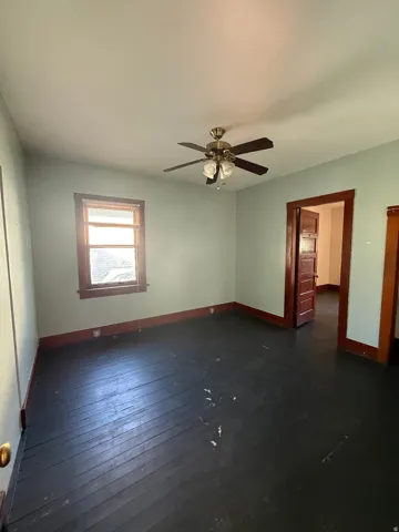 Room featuring dark wood-finish flooring and light-toned walls