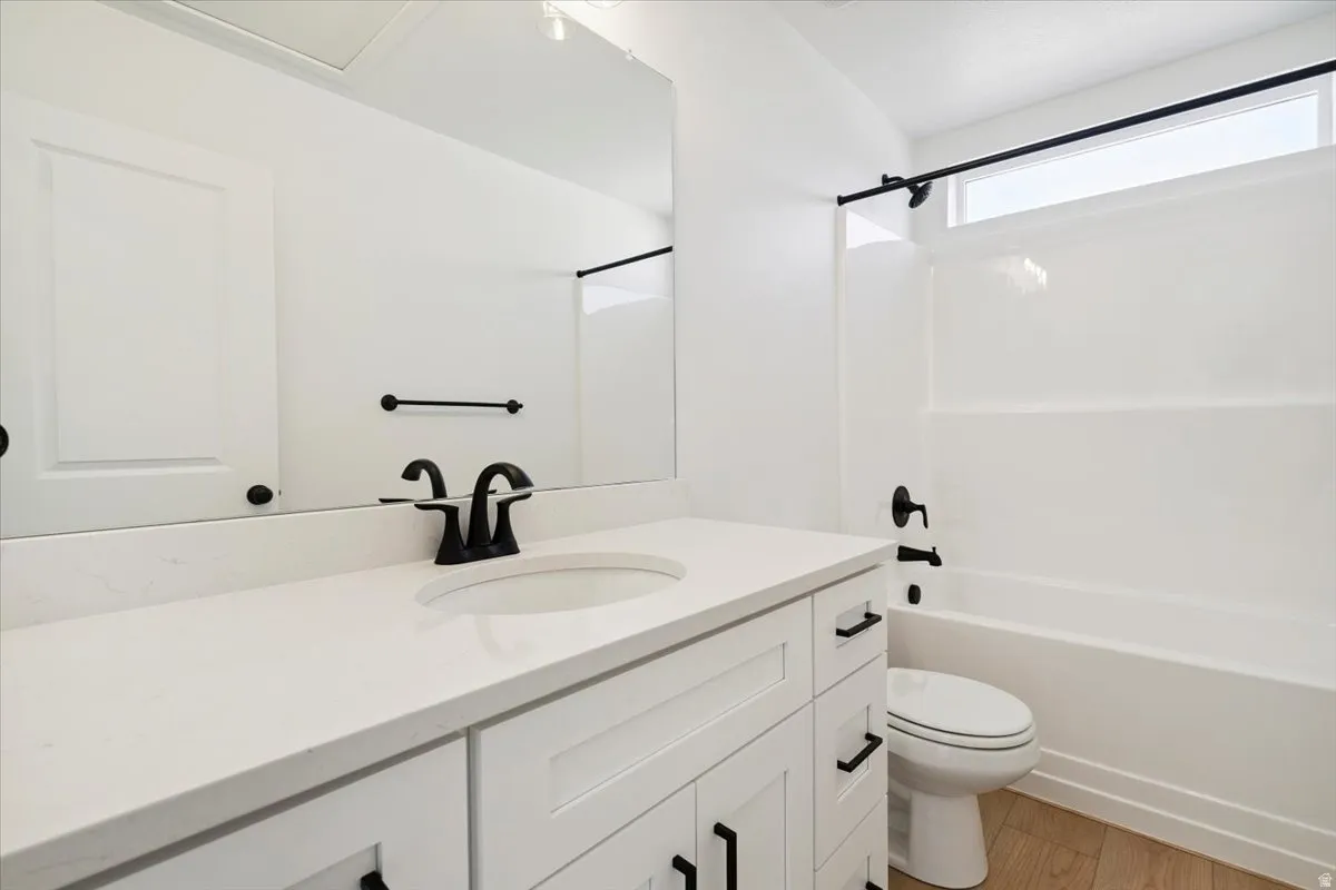 Bathroom featuring a white vanity with recessed panel cabinetry, a white countertop, and a single undermount sink with a matte black faucet