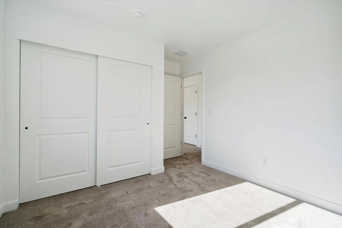 Room featuring neutral-toned carpeting, white walls, and white baseboards