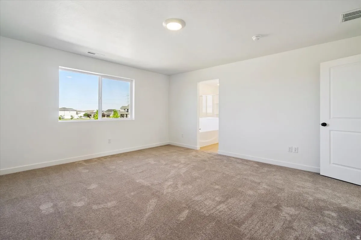 Spacious interior with neutral carpeting and white walls