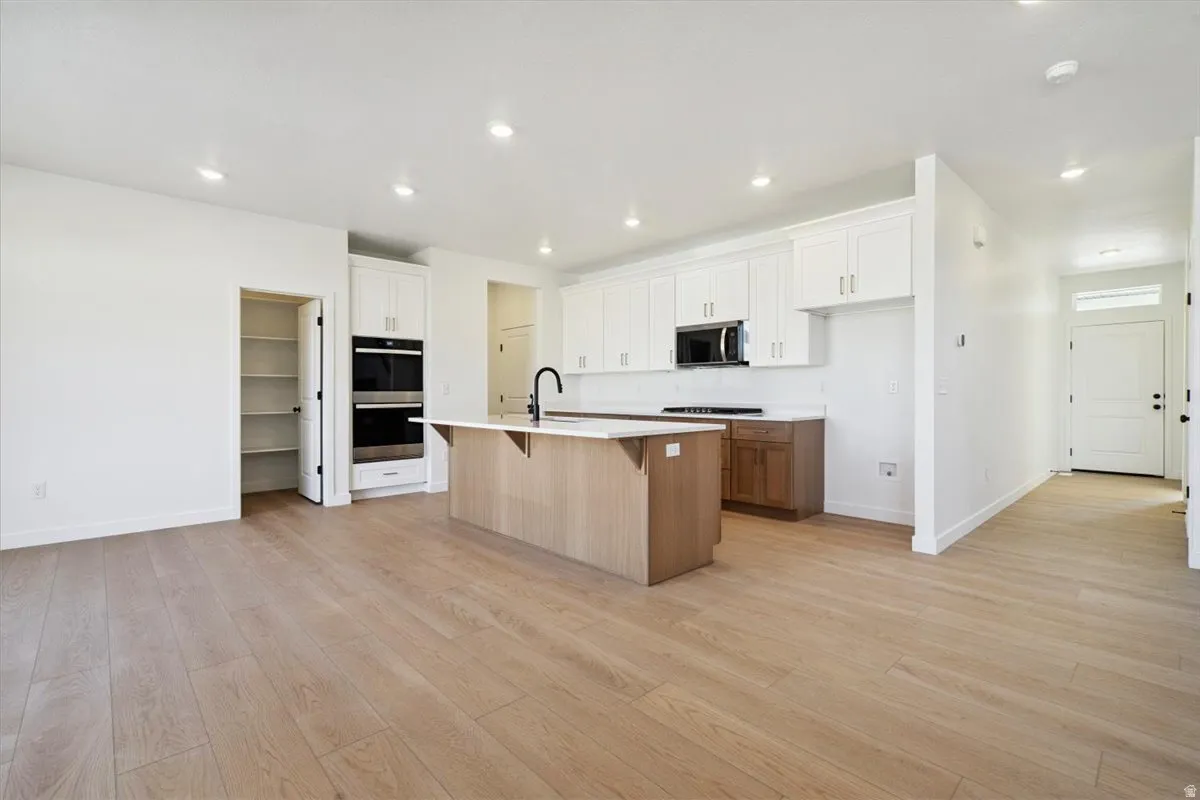 Open-concept kitchen and living area featuring wood-finish flooring