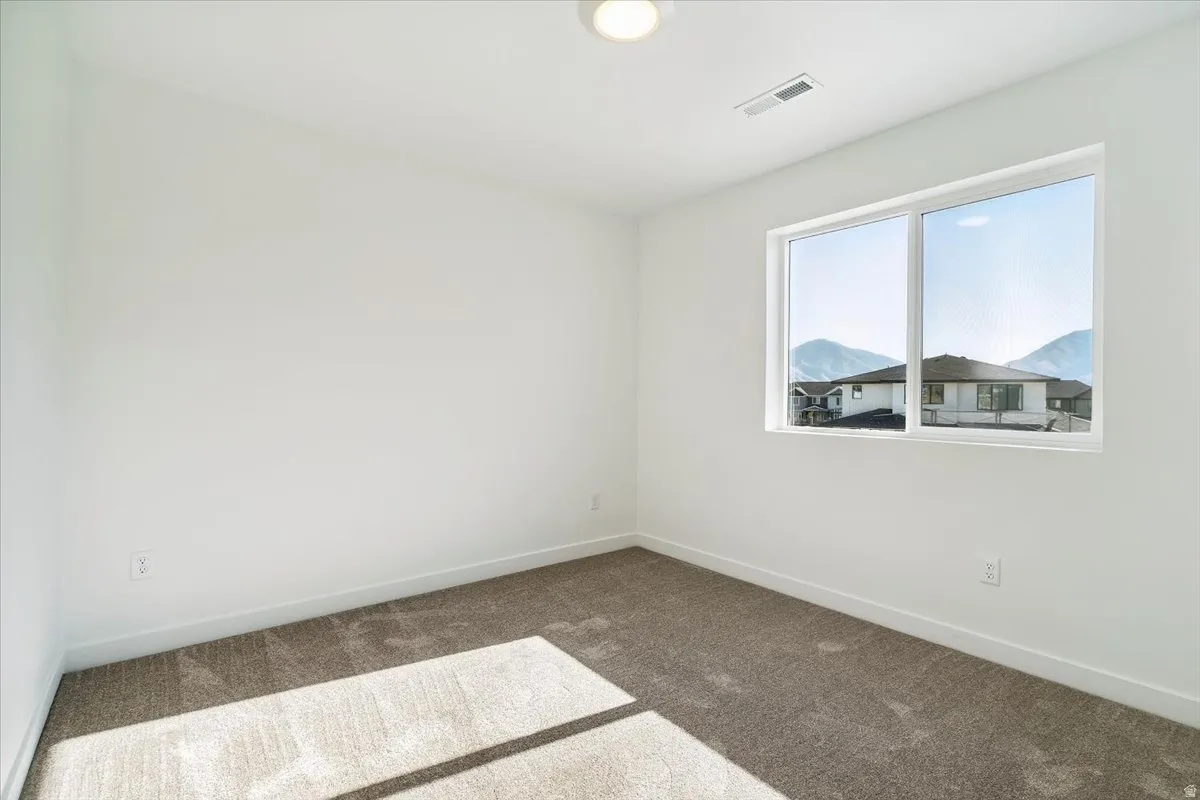 Spacious interior with neutral white walls and tan carpeting