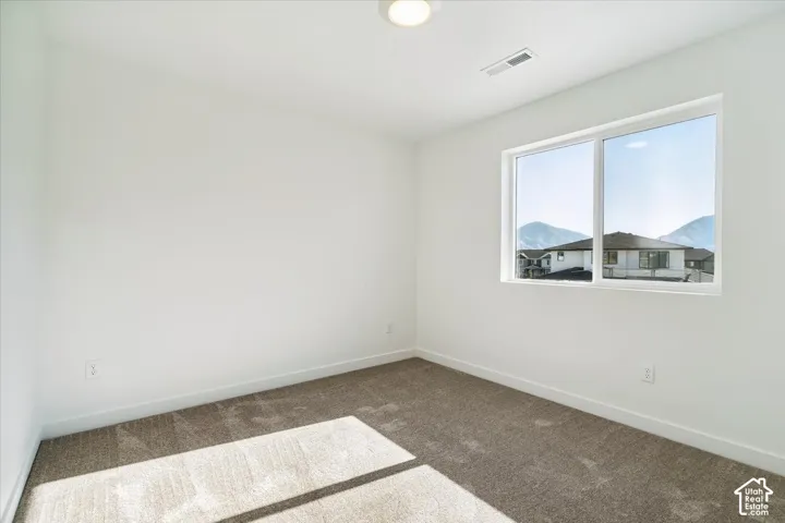 Spacious interior with neutral white walls and tan carpeting