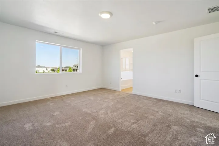 Spacious interior with neutral carpeting and white walls