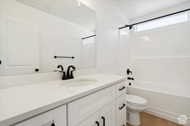 Bathroom featuring a white vanity with recessed panel cabinetry, a white countertop, and a single undermount sink with a matte black faucet