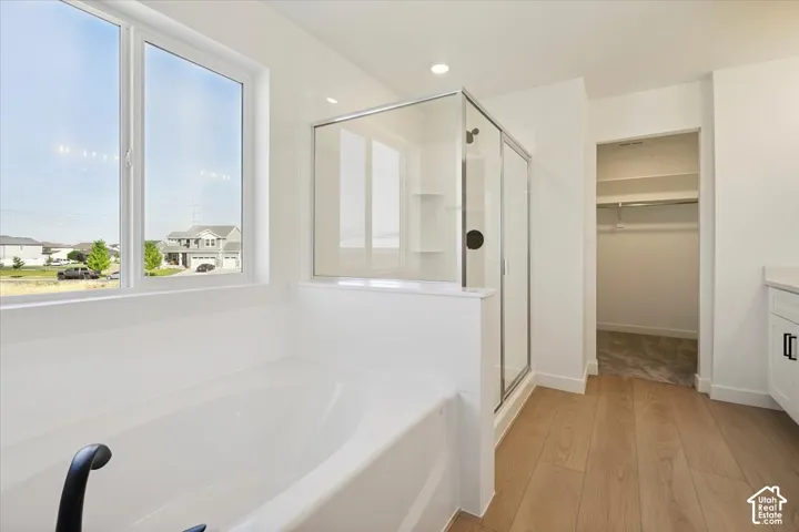 Soaking tub with black fixtures, framed by a large window