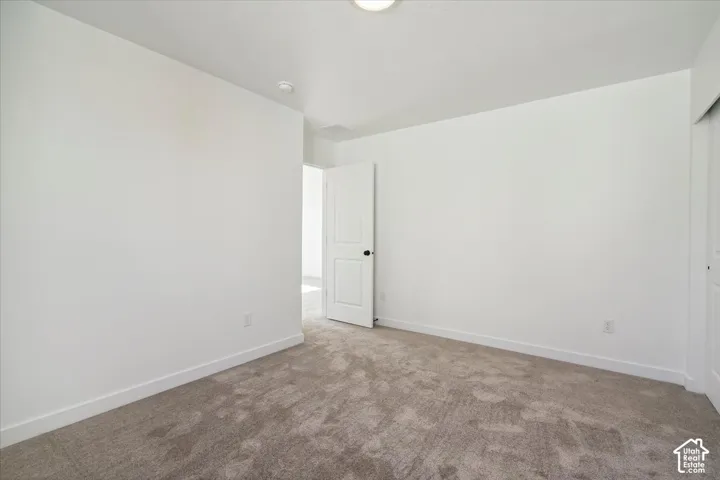 Spacious room featuring neutral carpeting and white painted walls