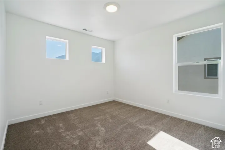 Carpeted interior room featuring white walls and a contemporary flush-mount ceiling light