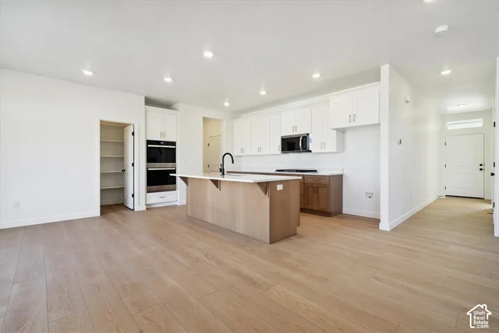 Open-concept kitchen and living area featuring wood-finish flooring