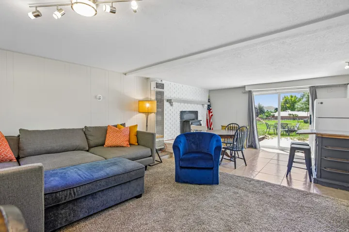 Open-concept living area featuring track lighting, a built-in fireplace, and a sliding glass door providing direct outdoor access