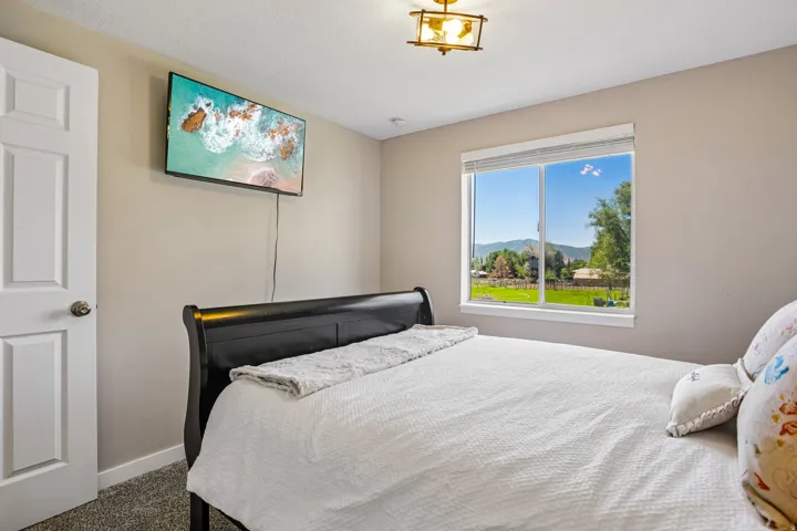 Room featuring a large window, neutral wall paint, and textured carpeting