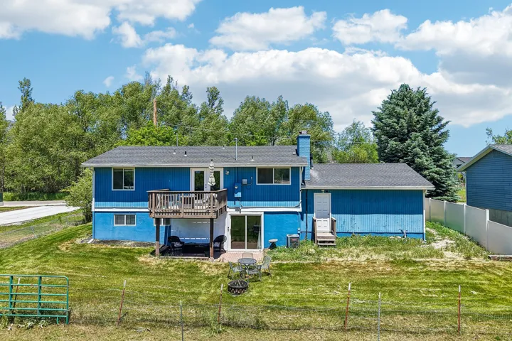Two-story residence featuring a blue exterior with dark roofing