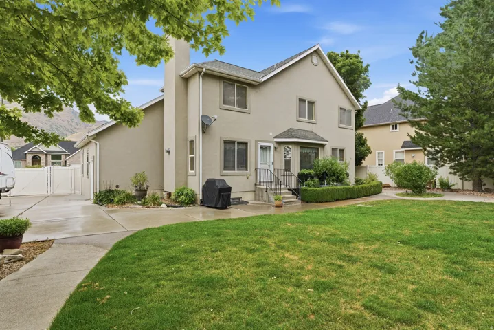 Two-story residence featuring a neutral-toned exterior, multiple windows, and a bay window