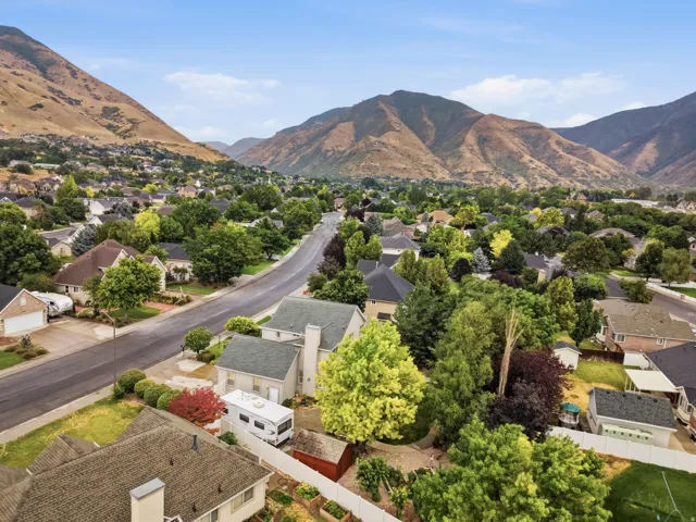 Residential neighborhood featuring mature trees and mountain scenery