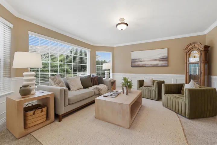 Bay window with window blinds, crown molding, chair rail molding, and a built-in ceiling light fixture