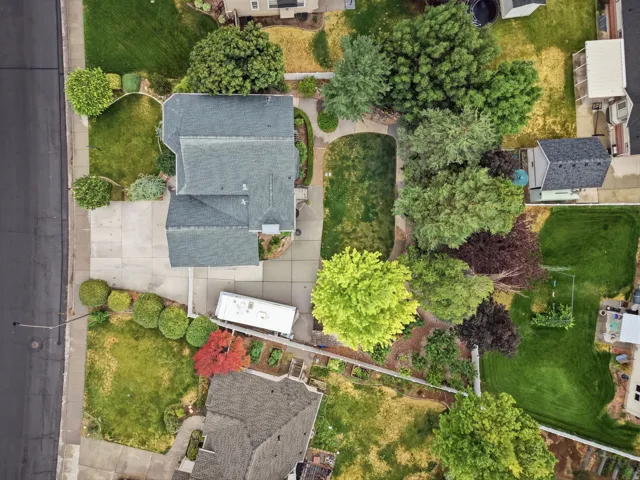 Property featuring a gray shingled roof and a concrete driveway