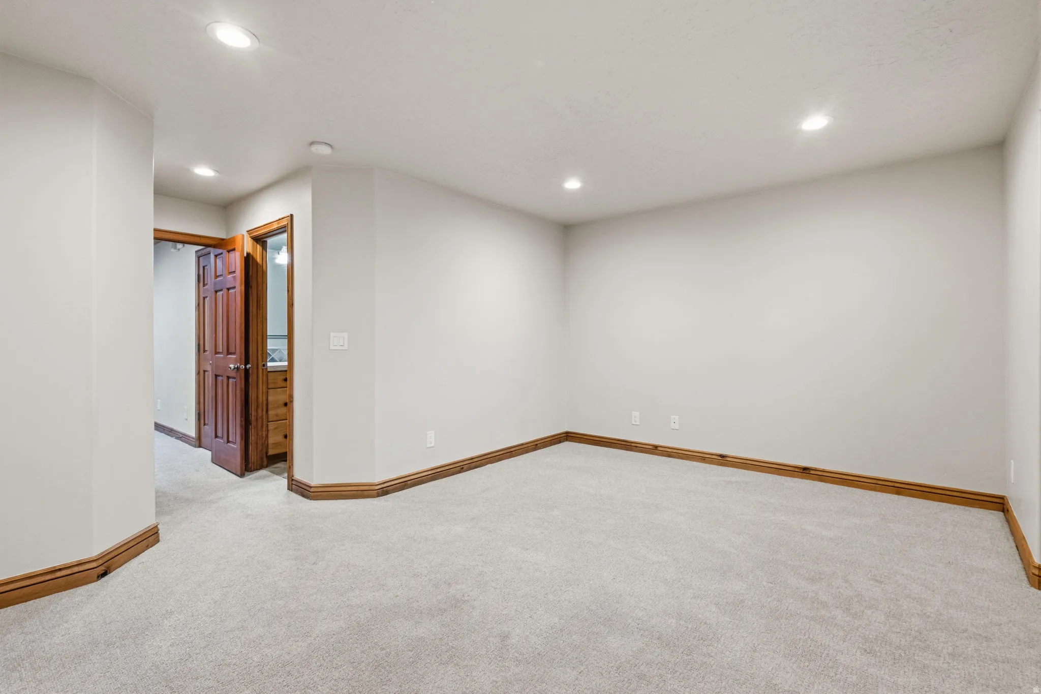 Neutral wall tones complement the light-toned carpet flooring