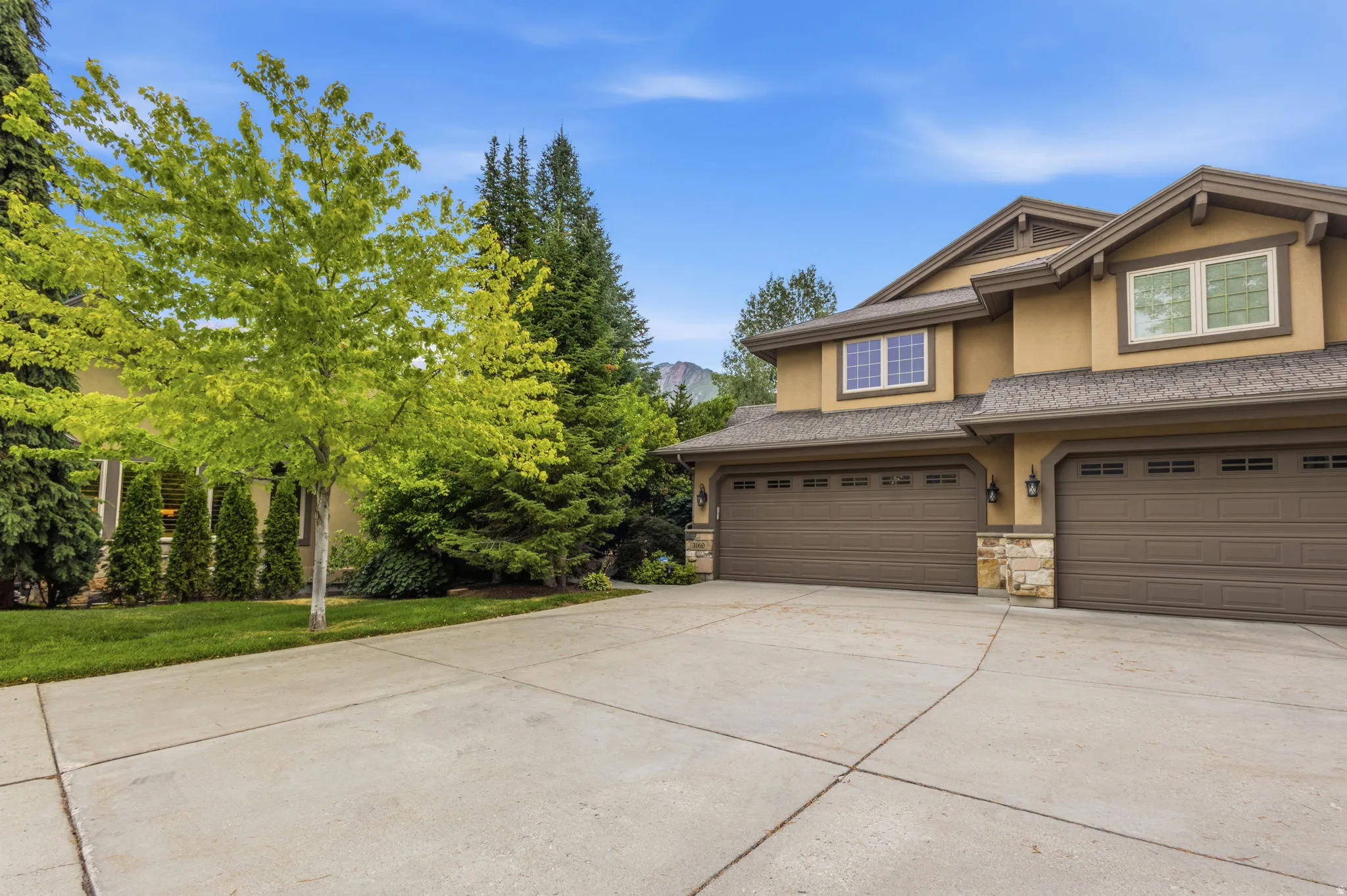 Multi-car garage with two separate doors and exterior stone accents
