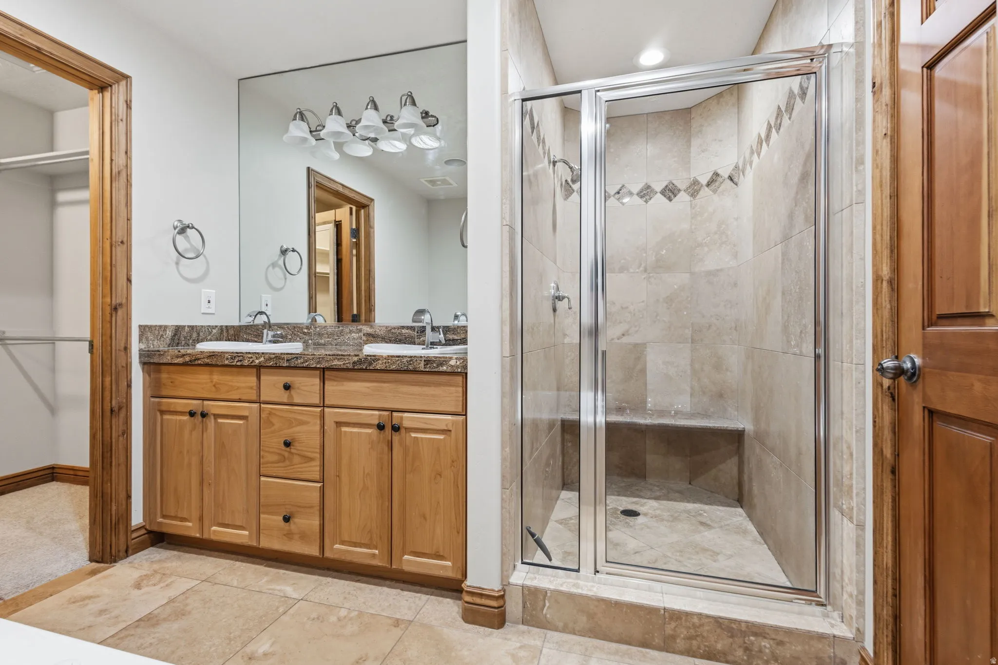 Bathroom featuring a glass-enclosed shower with tile surround and integrated bench