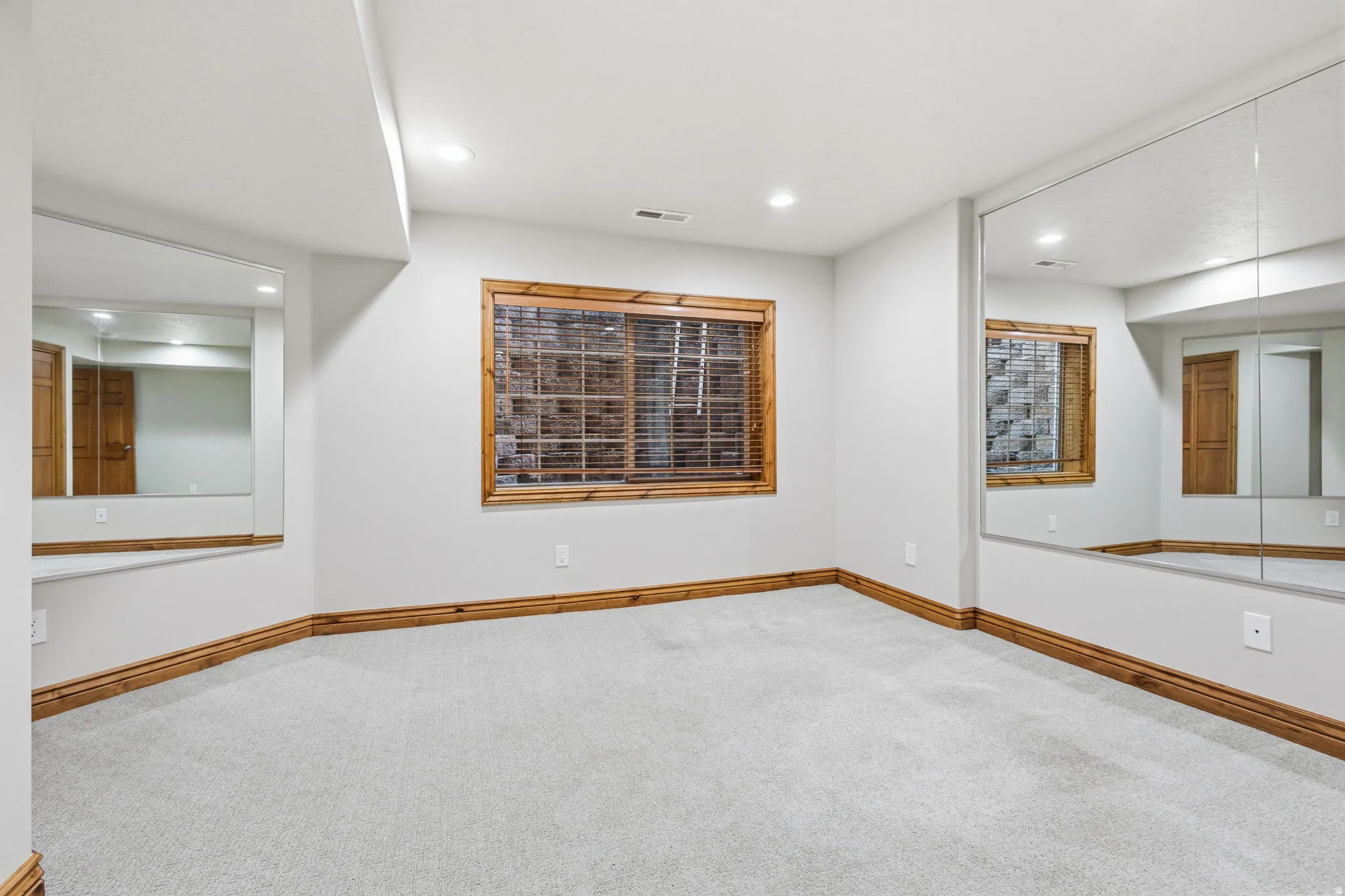 Room featuring wall-to-wall mirrors, light gray carpeting, and recessed lighting