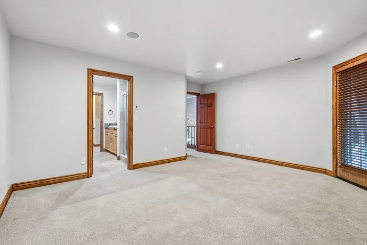Carpeted room with recessed lighting and natural wood trim throughout