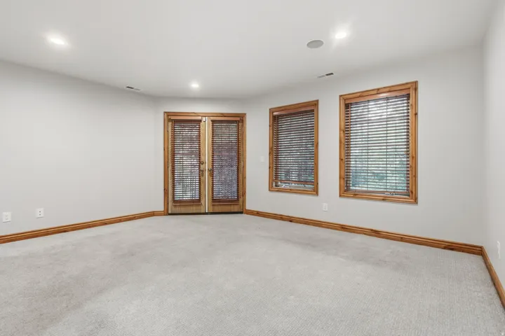 Recessed lighting illuminates this room featuring carpeted flooring and light gray walls
