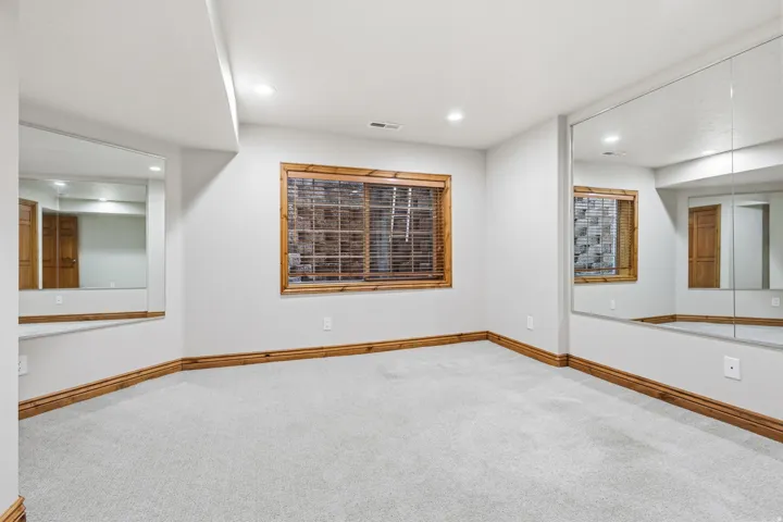 Room featuring wall-to-wall mirrors, light gray carpeting, and recessed lighting