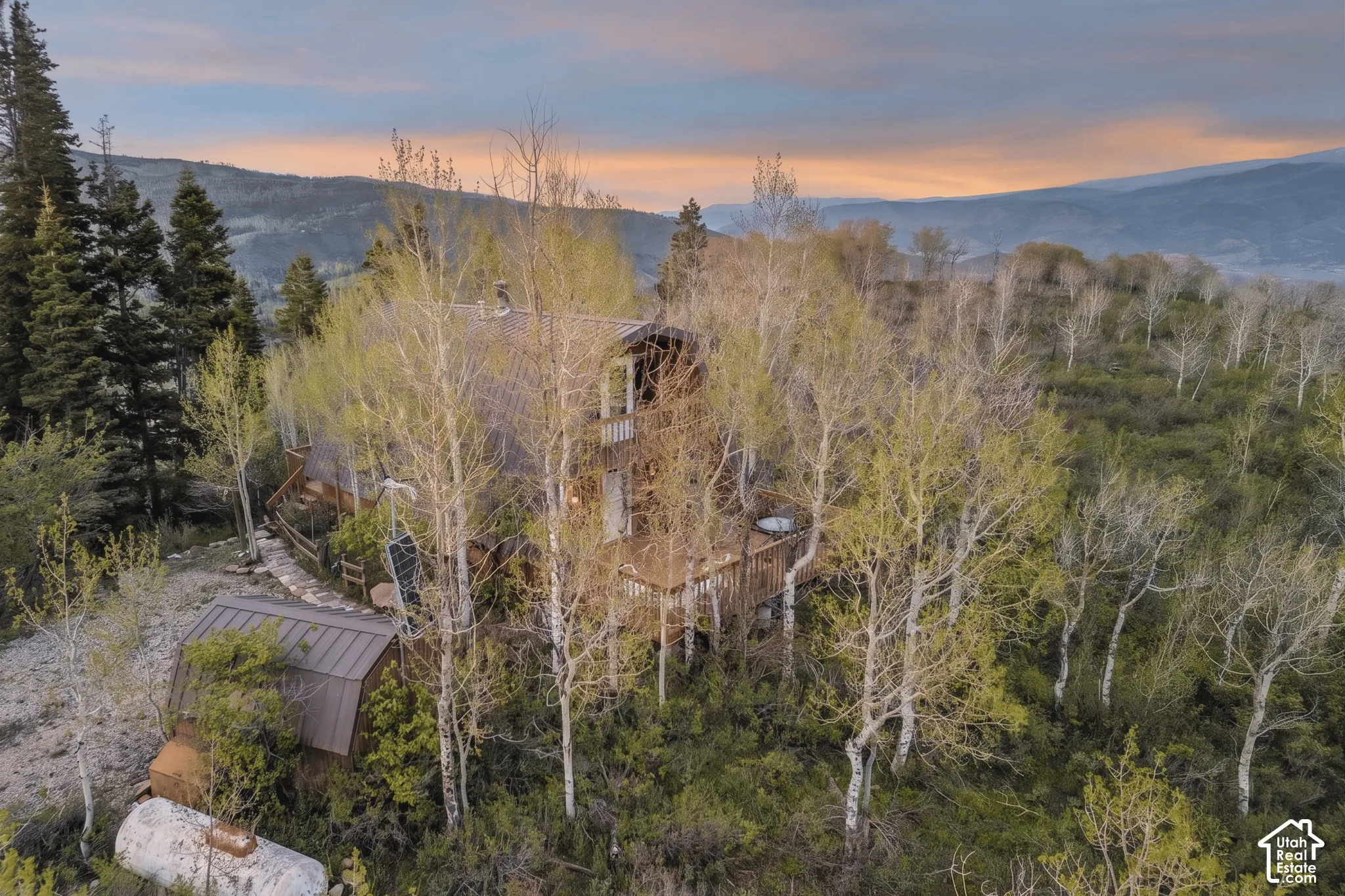 Aerial with Outbuildings Overhead view showing the cabin, detached shed, propane tank, and cleared approach.