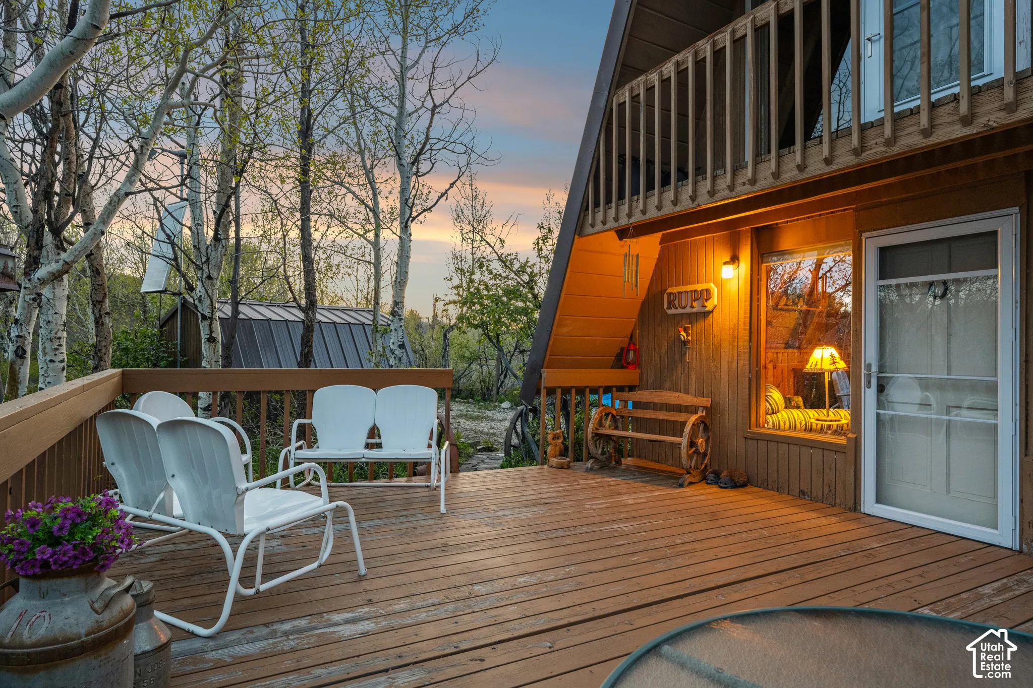 Deck Seating - Wraparound deck with multiple seating areas and direct access to the main level, backed by aspen groves and a detached outbuilding.