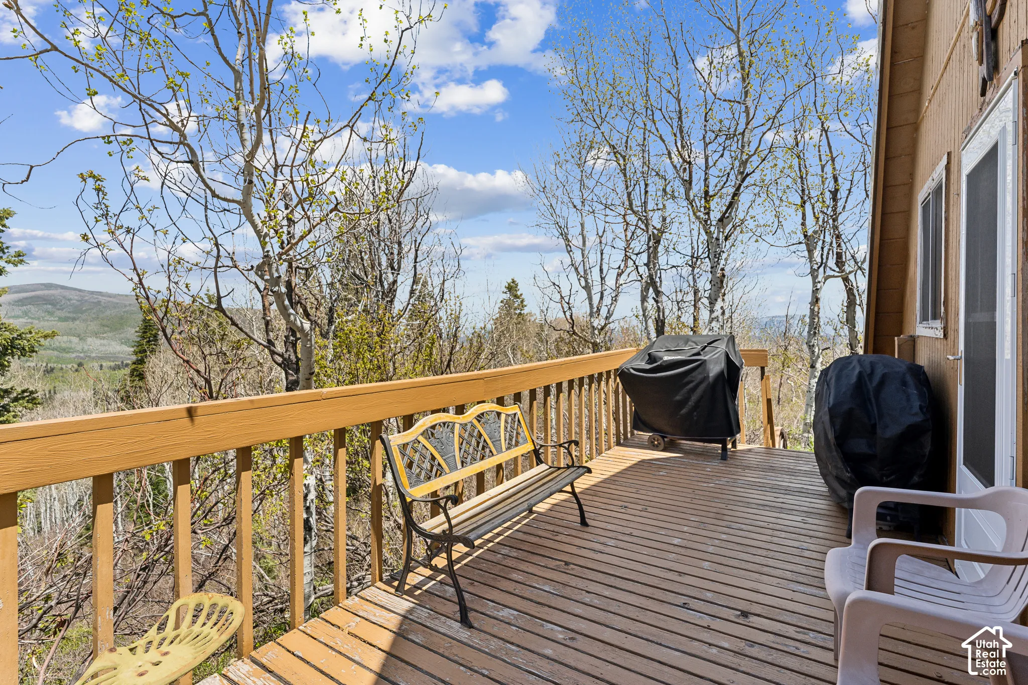 Side Deck - Side deck with bench seating, grill space, and open views across the hillside.