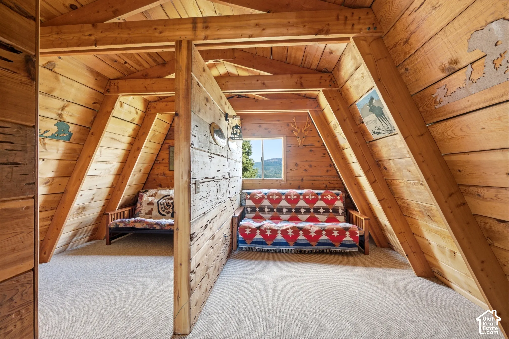 Second Bedroom - Upper bedroom under the A-frame roofline, with a center post detail, carpet, and a window framing the ridge.