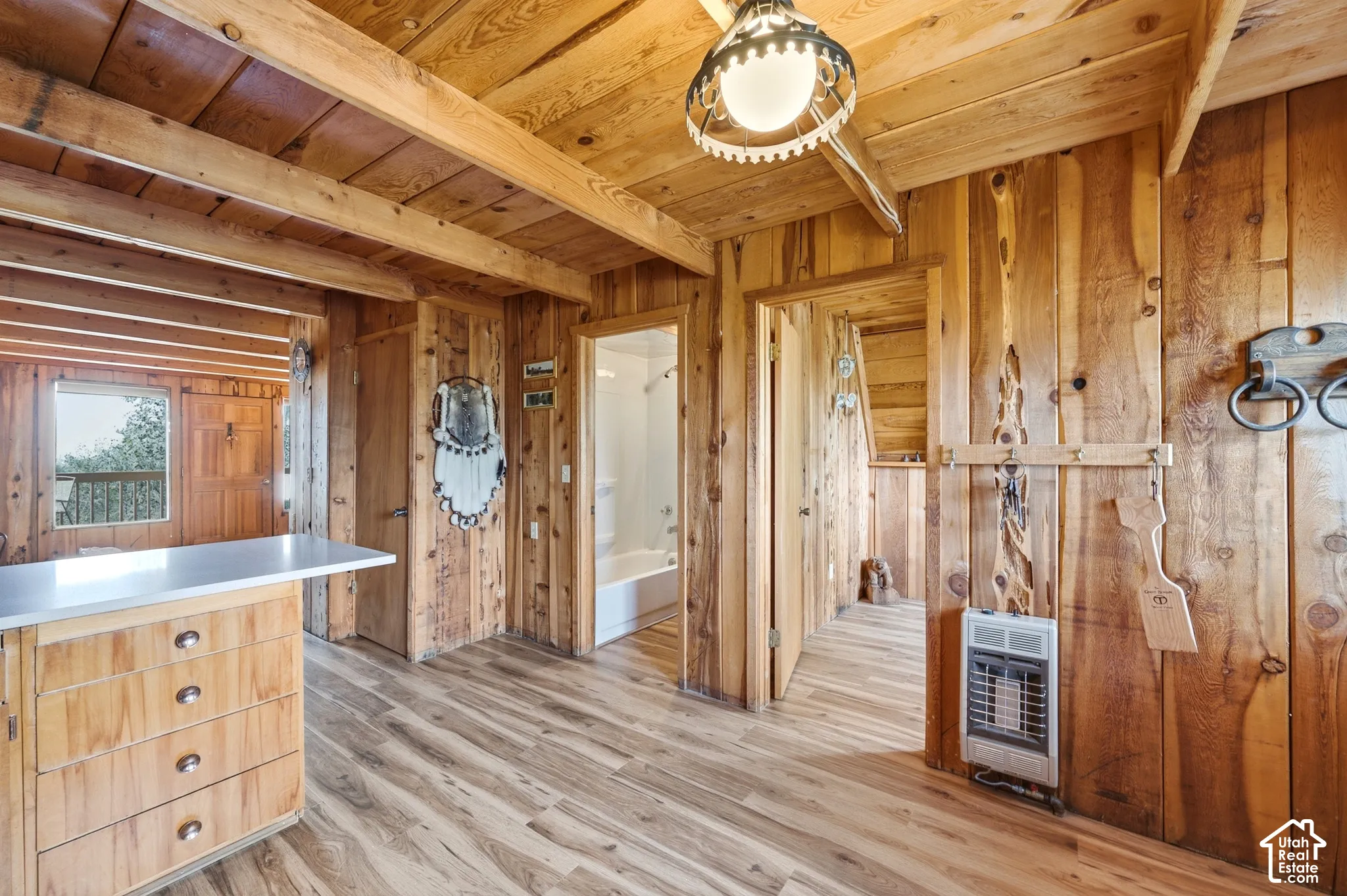 Kitchen to Hall - View from the kitchen toward the main-level hallway, full bath, and additional heating unit.
