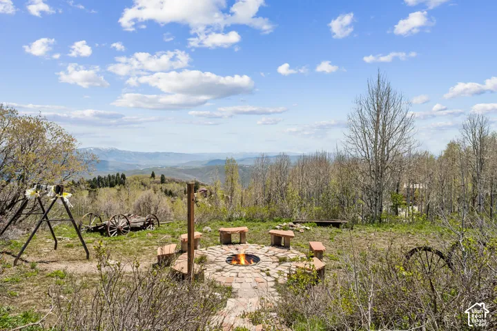 Fire Pit & Play Area - Gathering area with fire pit, bench seating, swing set, and vintage wagon-wheel accents.