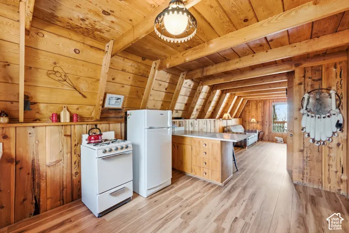 Kitchen Layout - Galley-style workspace opening directly into the adjacent living area, with exposed beams and continuous plank flooring.