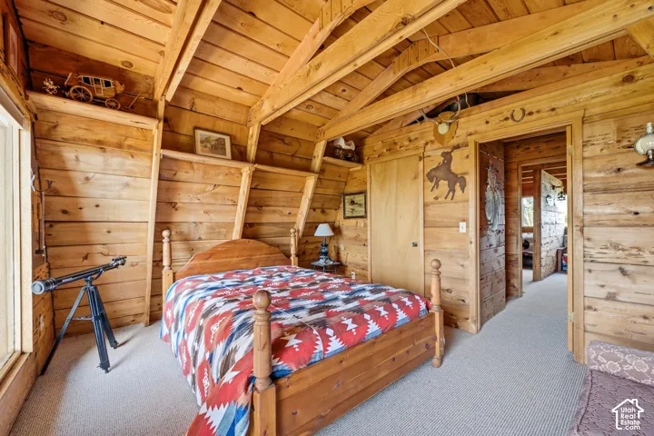 Bedroom - Bedroom with exposed beam ceiling, carpet, and a doorway opening to the adjoining upper-level space.