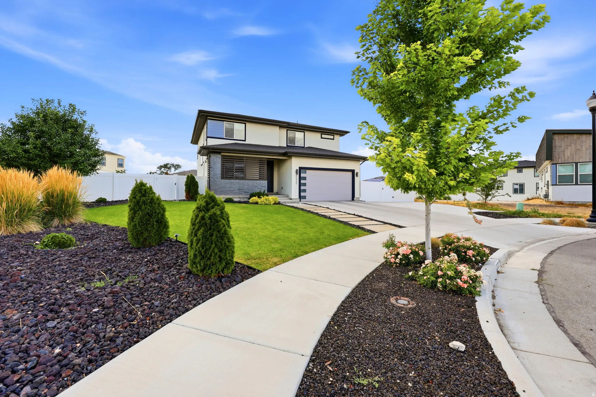 Contemporary two-story residence featuring a two-car garage and a concrete driveway