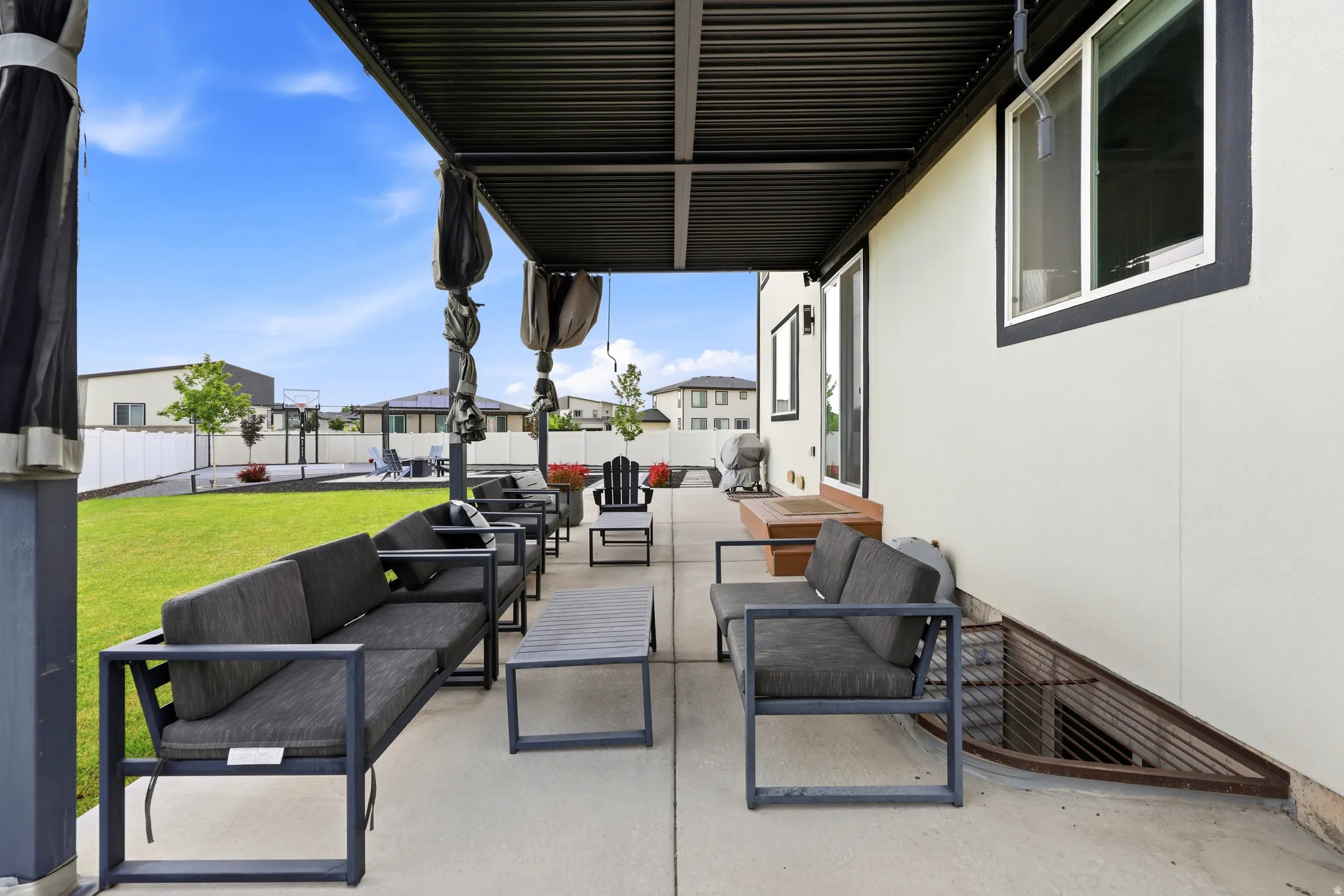 Expansive concrete patio featuring a louvered pergola with retractable shades
