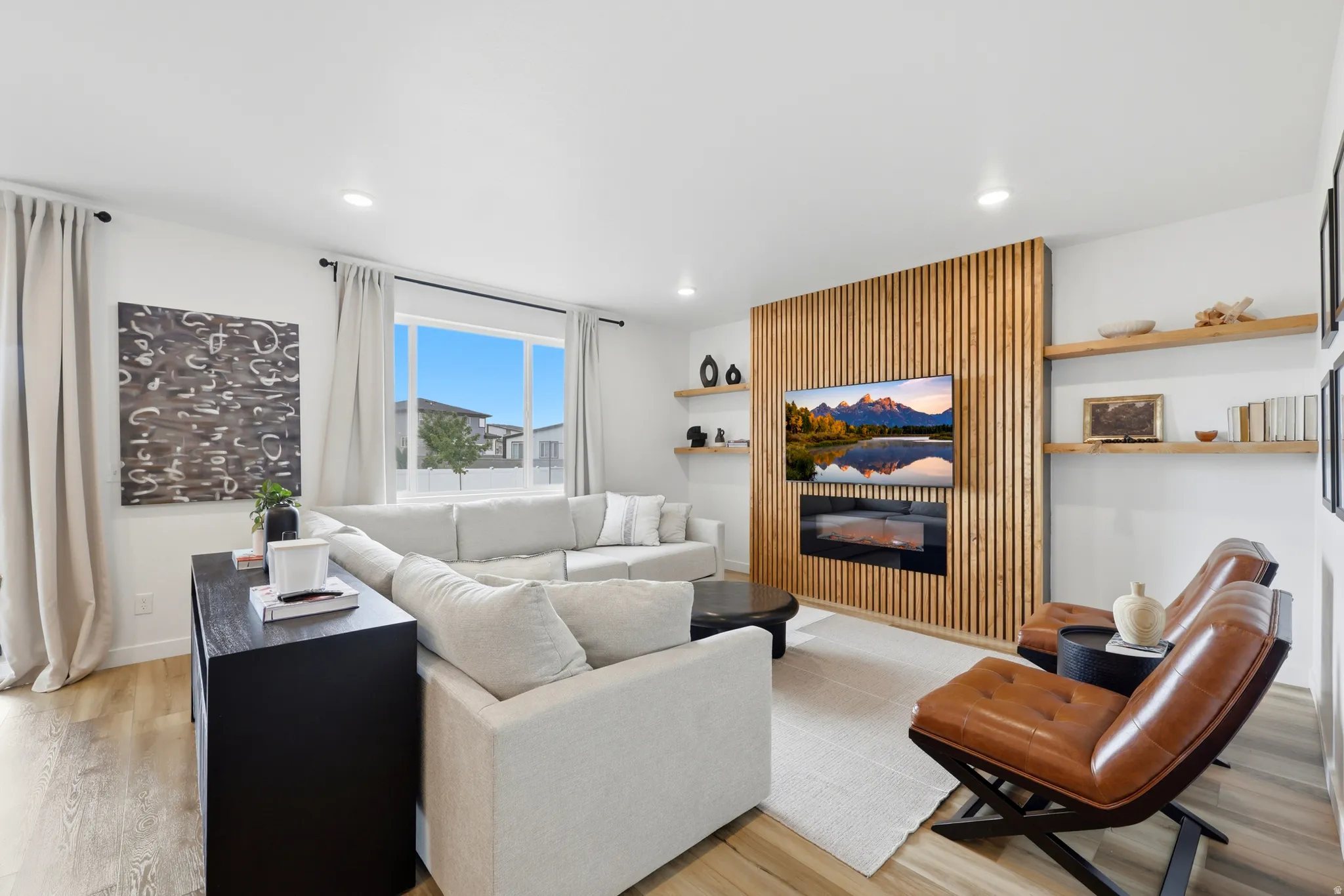 Open-concept living area featuring a wood-slat accent wall with an integrated electric fireplace