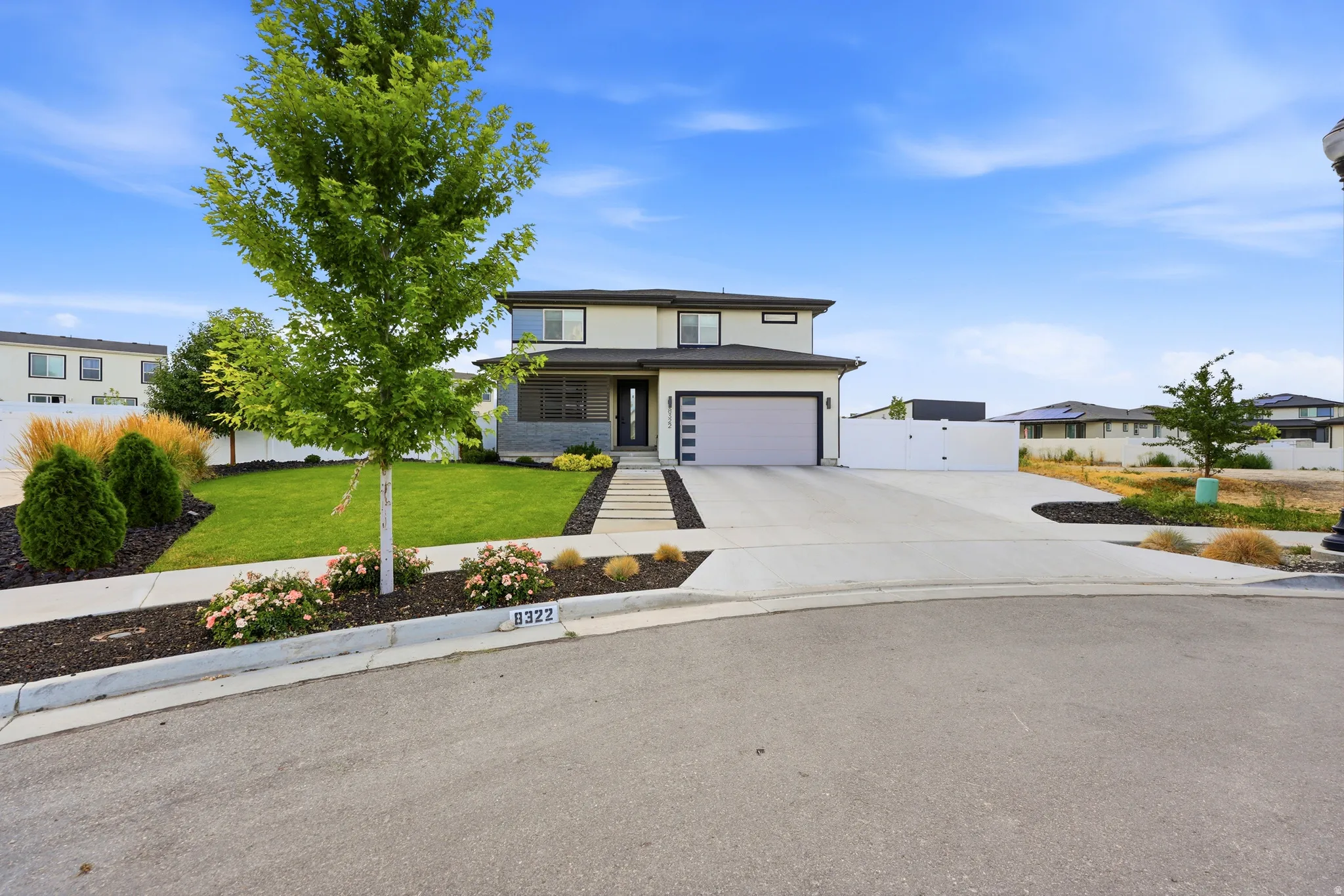 Contemporary two-story residence featuring a light-colored stucco exterior with dark trim accents