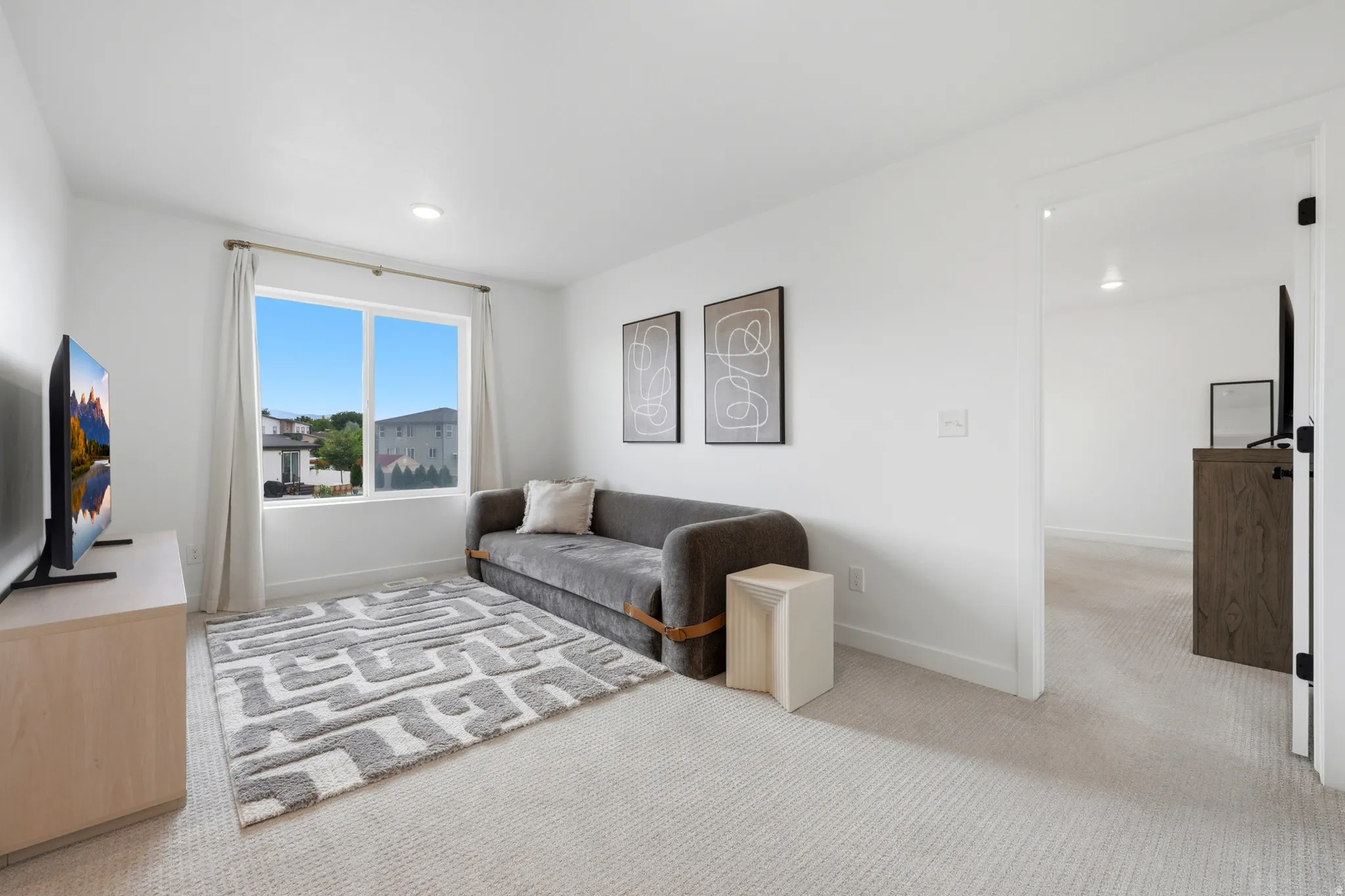 Light-filled room featuring a large window, recessed lighting, and light-toned carpeting