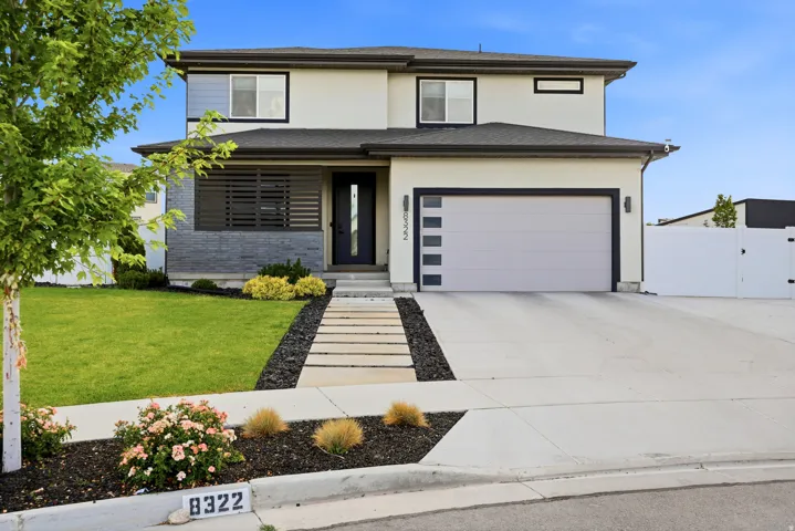 Modern two-story residence with a stucco exterior and dark trim accents