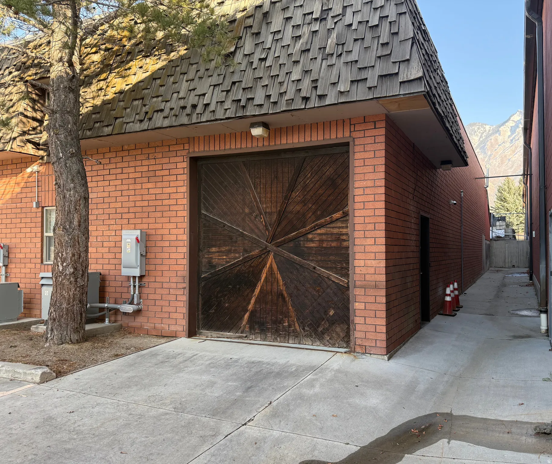 Brick exterior with a prominent wood garage door featuring a starburst pattern