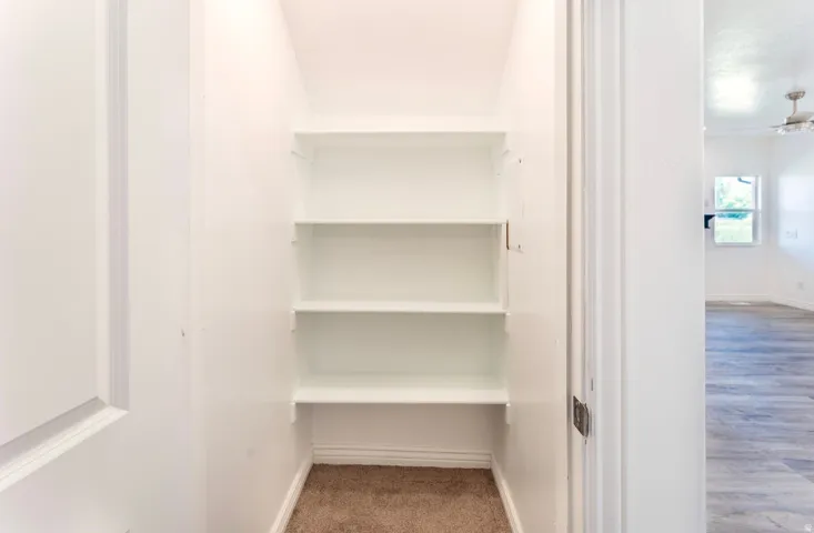 Dedicated storage closet featuring four built-in shelves with ample vertical space for organized storage and accessibility