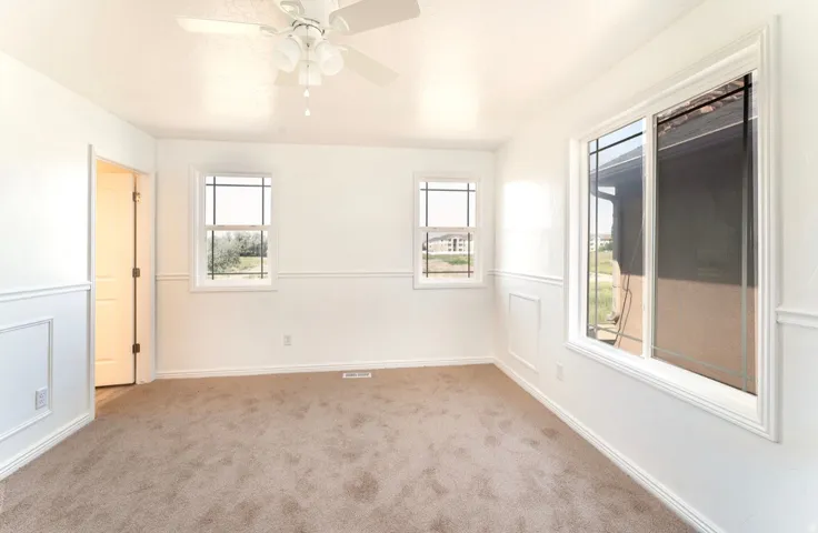 Bright and spacious room bathed in natural light from multiple windows and glass sliding doors