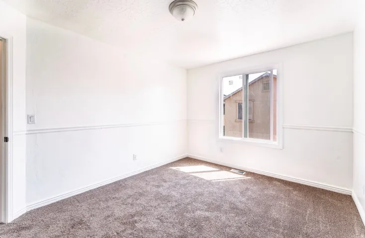 Carpeted room featuring a double-paned window, white baseboards, and chair rail molding