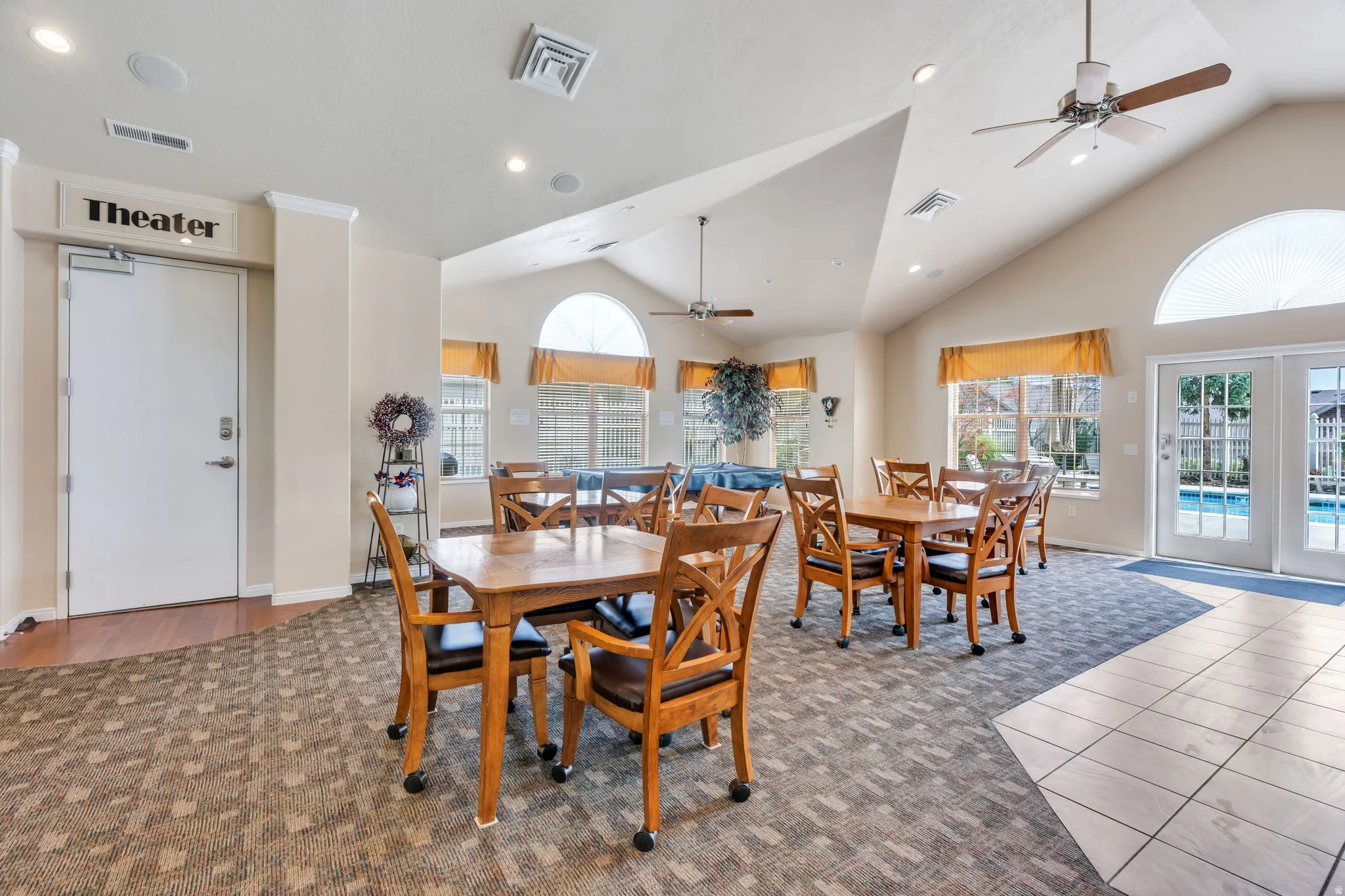 Spacious communal area featuring vaulted ceilings, recessed lighting, and multiple ceiling fans