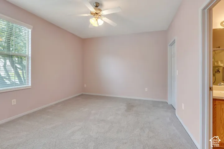 Spacious interior room featuring light-colored walls and soft carpeting