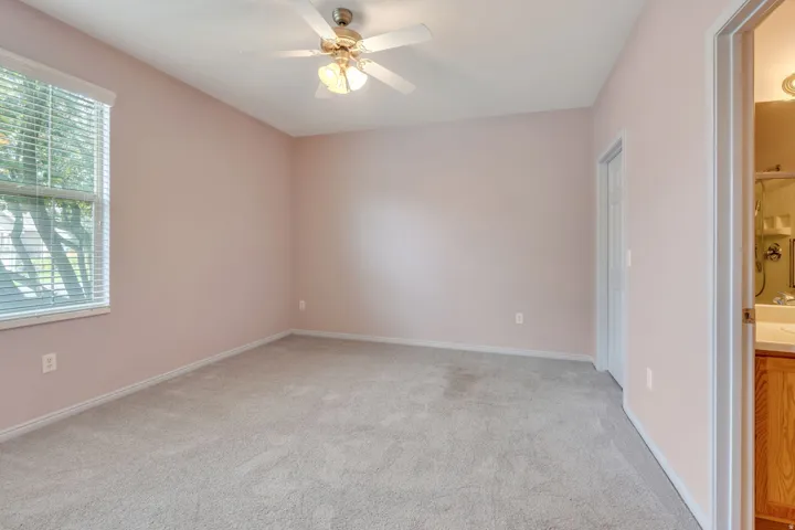Spacious interior room featuring light-colored walls and soft carpeting