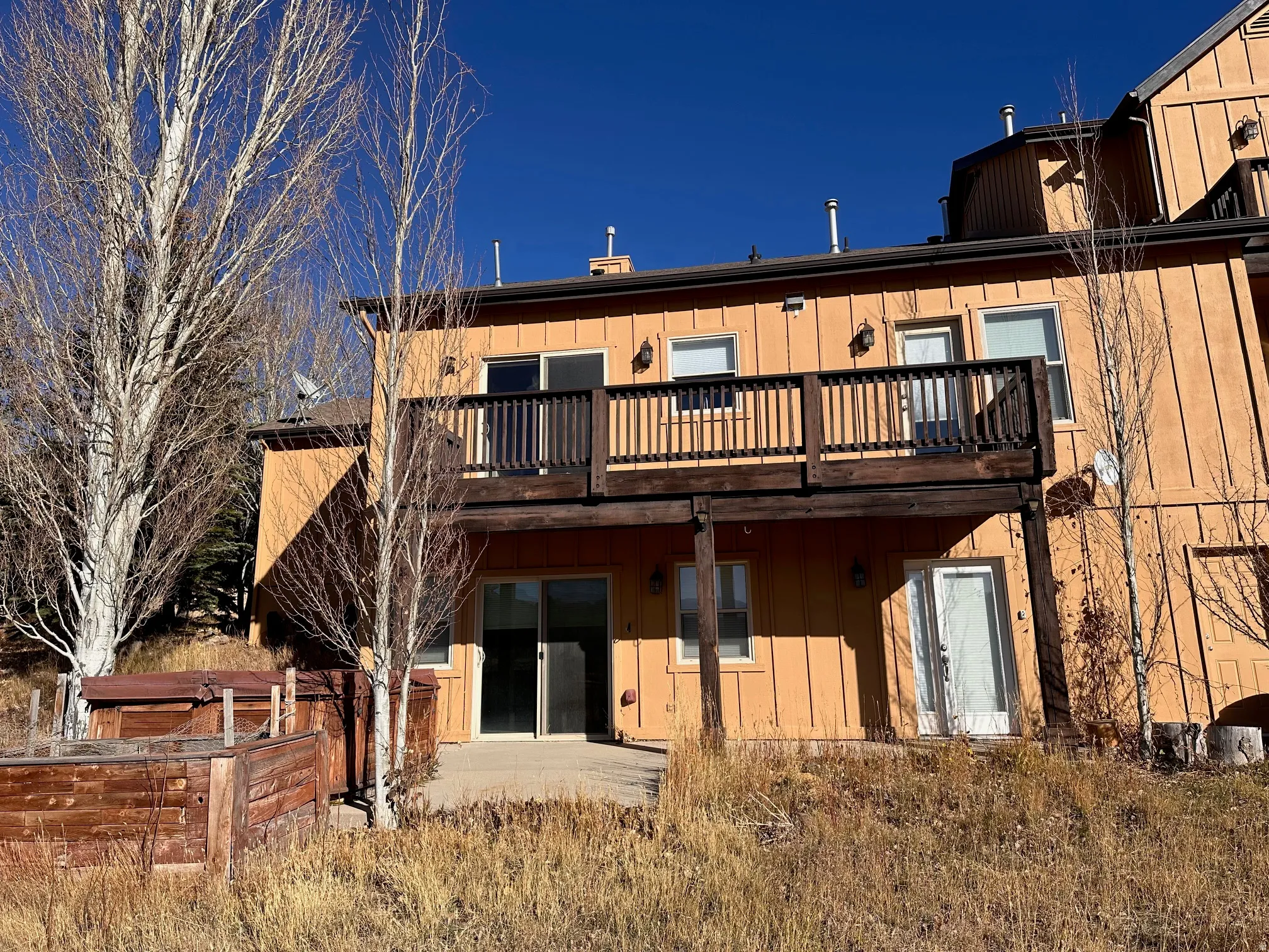 Multi-level property featuring a private upper deck with dark wood railing, offering outdoor access