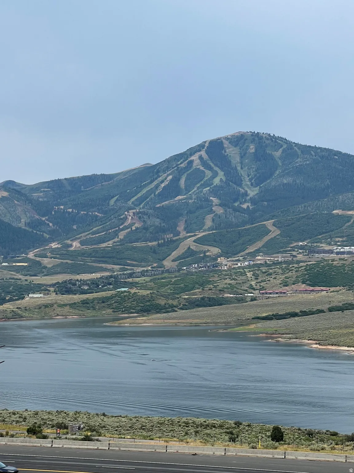 Mountain backdrop with ski runs and a lake